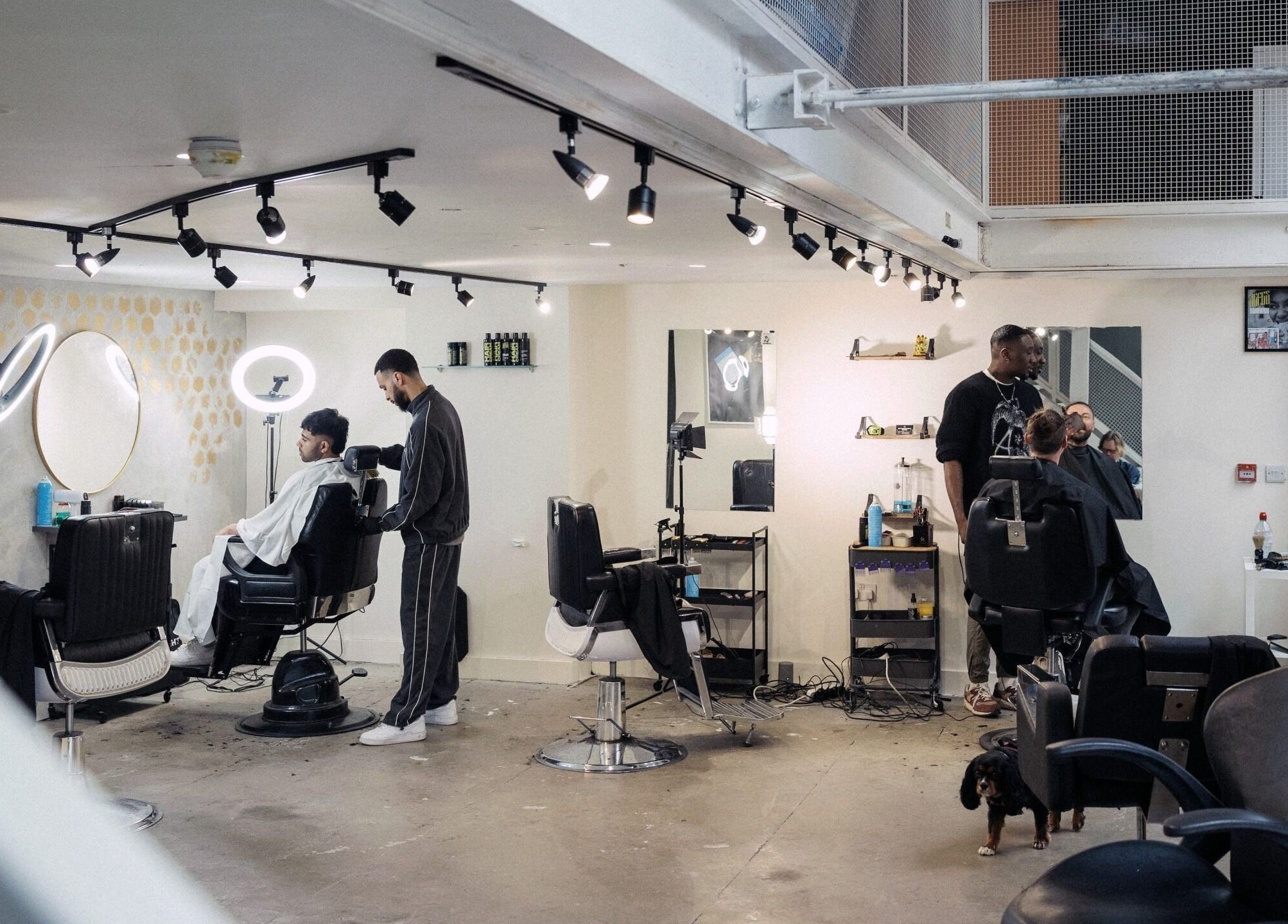 Inside view of Jefes Barbers - Altrincham, a modern barber shop in Altrincham, England, GB with clients getting haircuts.