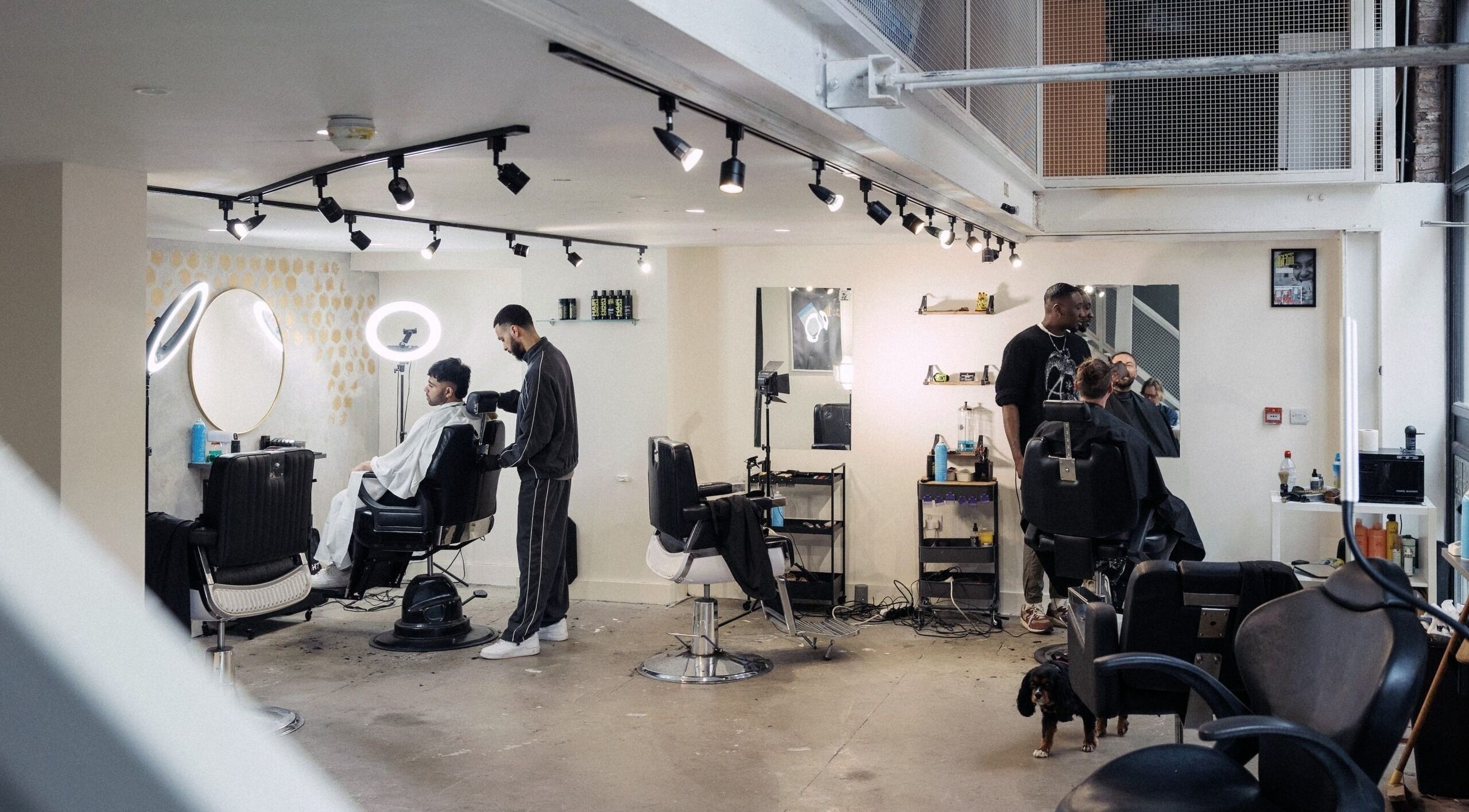 Inside view of Jefes Barbers - Altrincham, a modern barber shop in Altrincham, England, GB with clients getting haircuts.