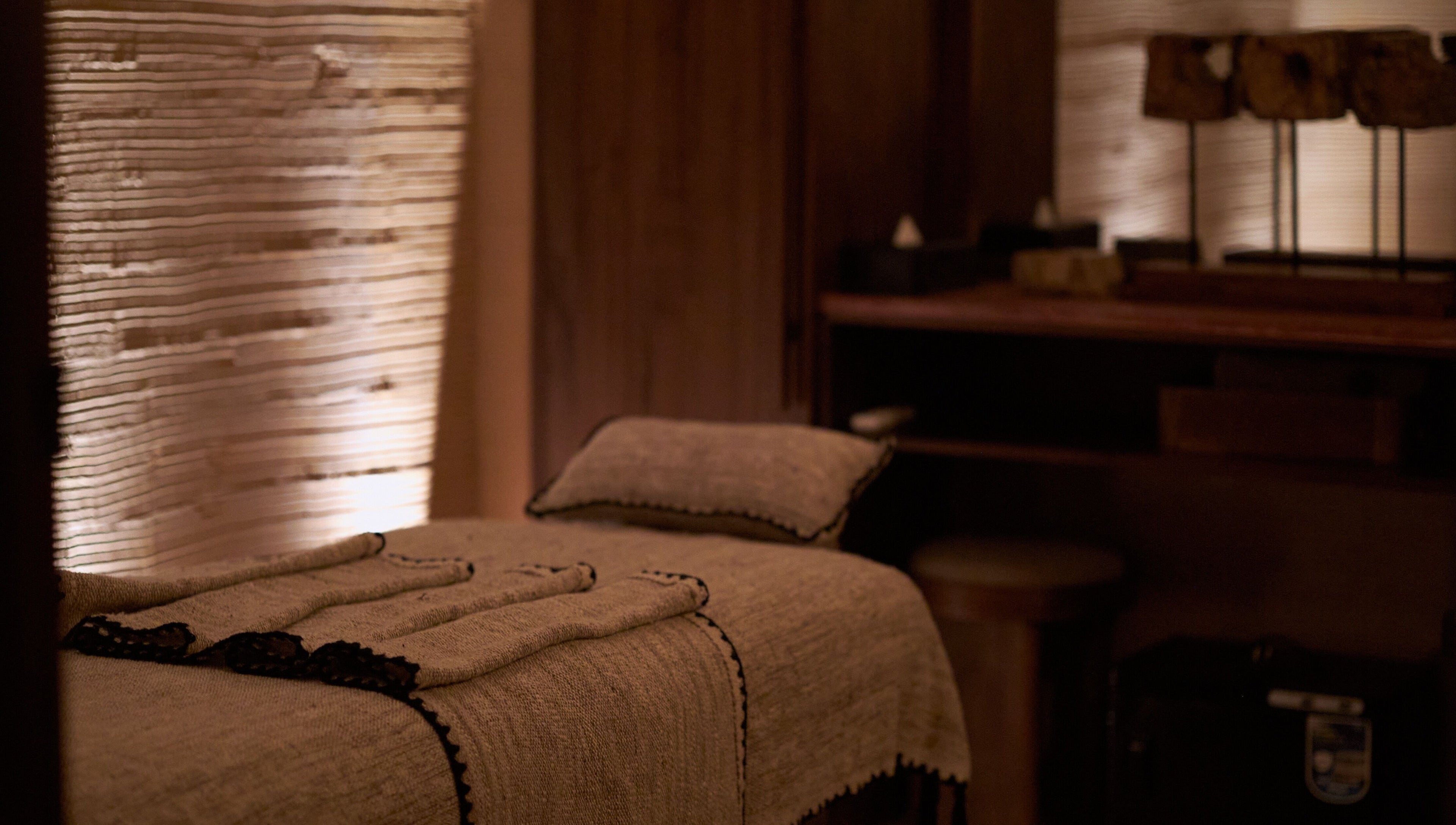 Relaxing massage room with soft lighting at ATMOS BodyLab, Bali, Bali, ID. Tranquil ambiance for wellness.