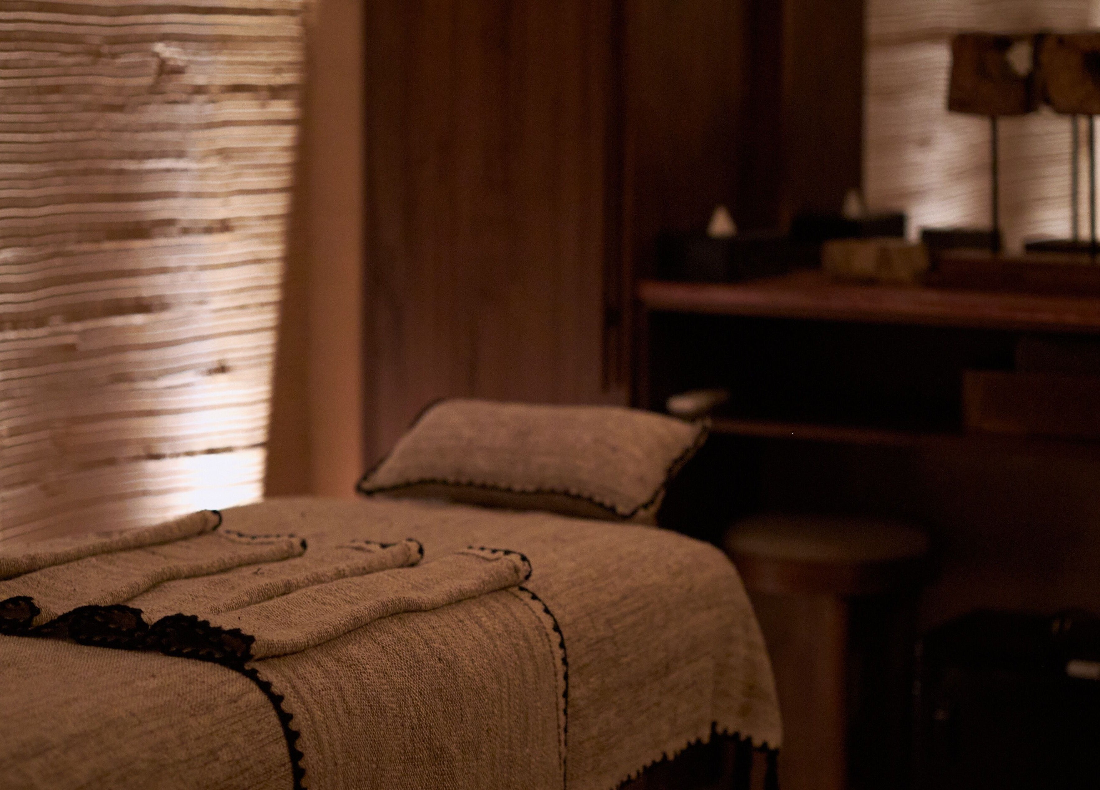Relaxing massage room with soft lighting at ATMOS BodyLab, Bali, Bali, ID. Tranquil ambiance for wellness.