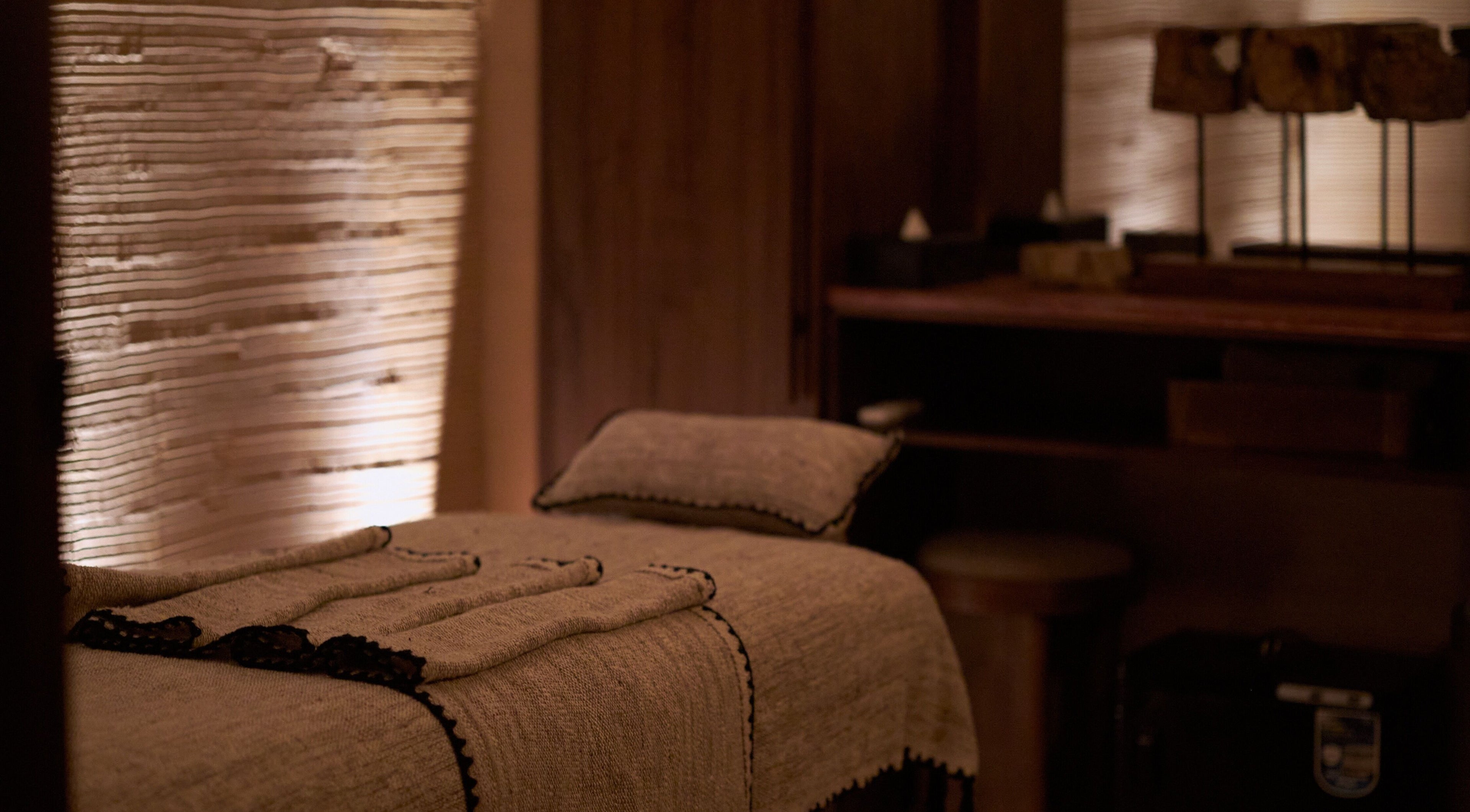 Relaxing massage room with soft lighting at ATMOS BodyLab, Bali, Bali, ID. Tranquil ambiance for wellness.