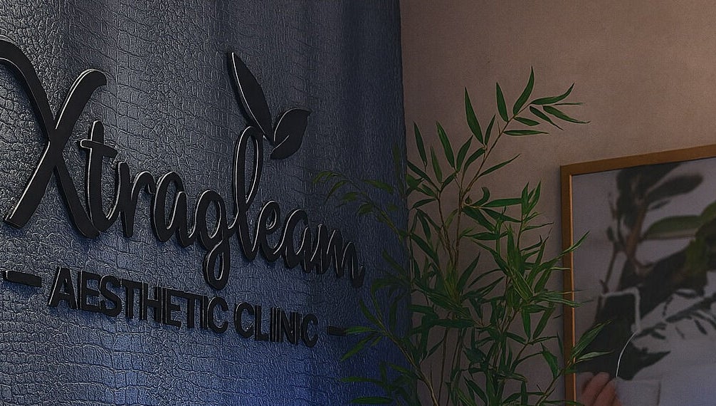 Xtragleam Aesthetic Clinic sign at Monshalasi busstop, Lagos, Lagos, NG, highlighted with plant décor.