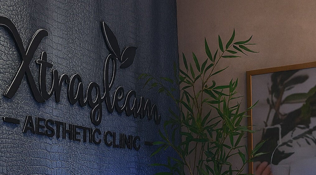 Xtragleam Aesthetic Clinic sign at Monshalasi busstop, Lagos, Lagos, NG, highlighted with plant décor.