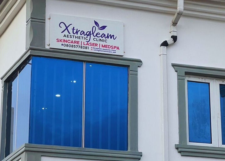 Exterior view of Xtragleam Aesthetic Clinic in Ishara, Ogun State, NG, featuring modern blue-tinted windows.