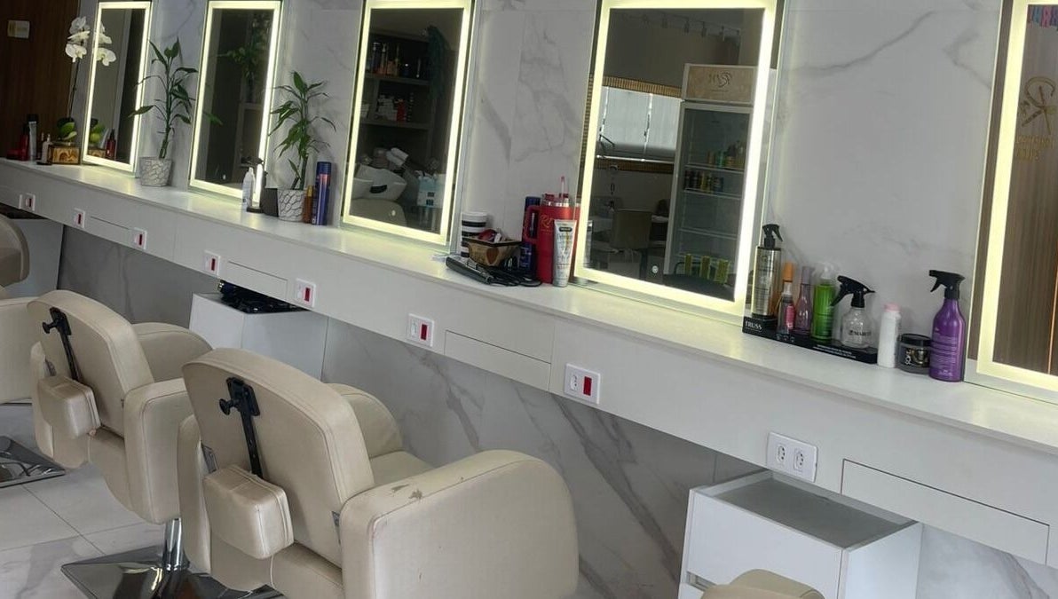 Interior moderno do Renata Magalhães studio em São Paulo, BR, com espelhos iluminados e cadeiras de salão.