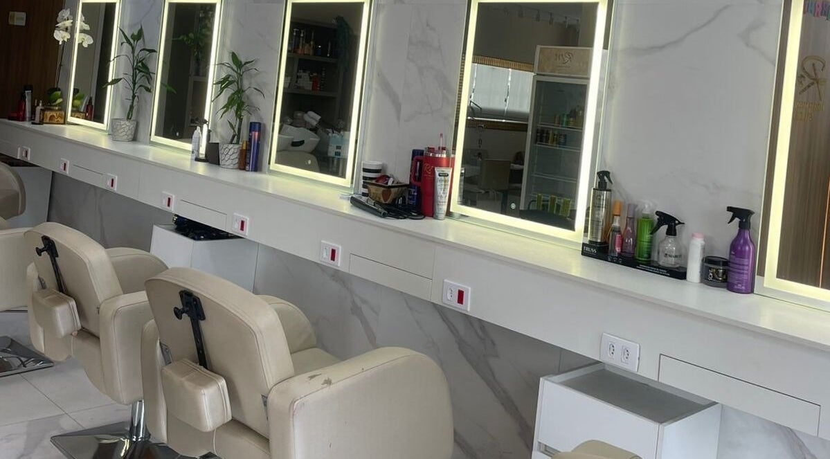 Interior moderno do Renata Magalhães studio em São Paulo, BR, com espelhos iluminados e cadeiras de salão.