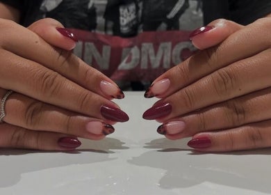 Manucure élégante à Nailuxe, La Prairie, Québec, CA avec des teintes bordeaux et bouts stylisés.