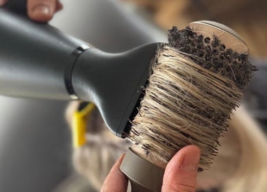 Professional hairstyling in action at F.P Hairdressing, Warfield, England, GB with a brush and dryer.
