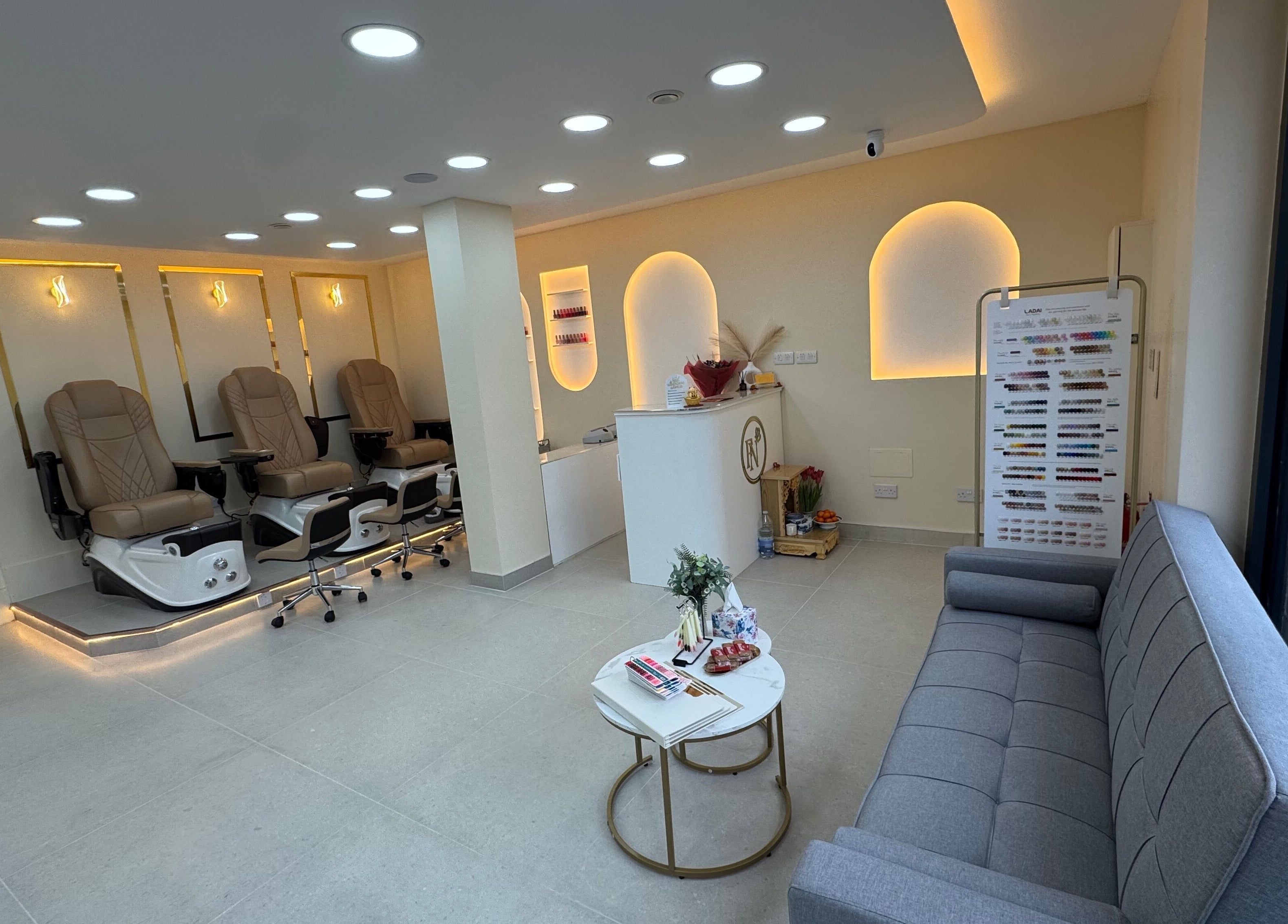 Relaxing lounge at Fancy Nails, London, England, GB, featuring plush seating and modern nail stations.