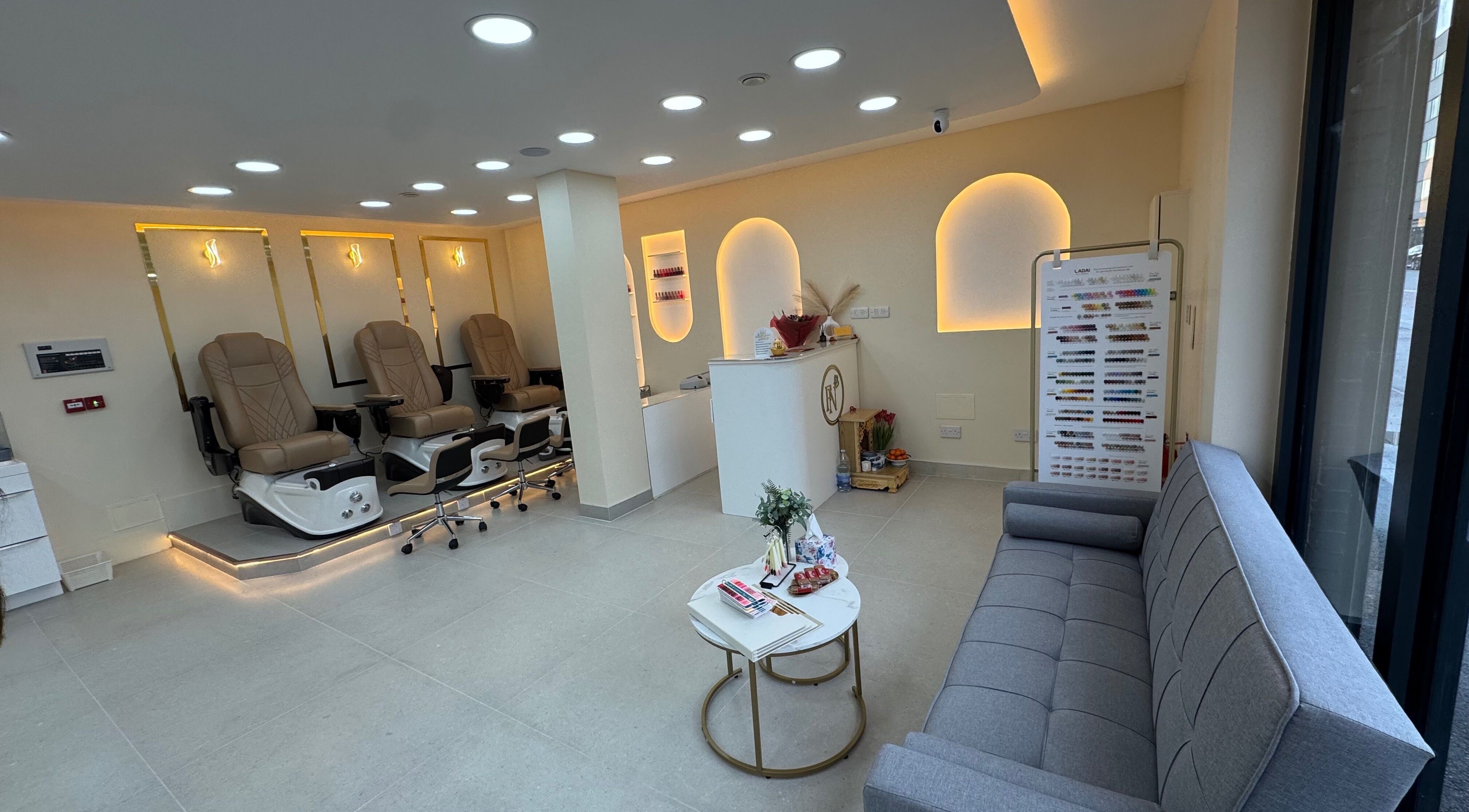Relaxing lounge at Fancy Nails, London, England, GB, featuring plush seating and modern nail stations.