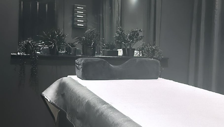 Therapy room at Precision Lifestyle Group in Manchester, England, GB, featuring a massage table with lush greenery.
