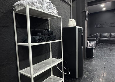 Interior do Brazilian Barber em Amadora, Lisboa, PT com toalhas e sofá preto.