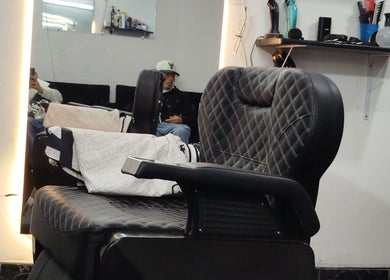 Moderna silla de barbero en Street Barbería, Soacha, Bogotá, D.C., CO, frente a espejo iluminado.