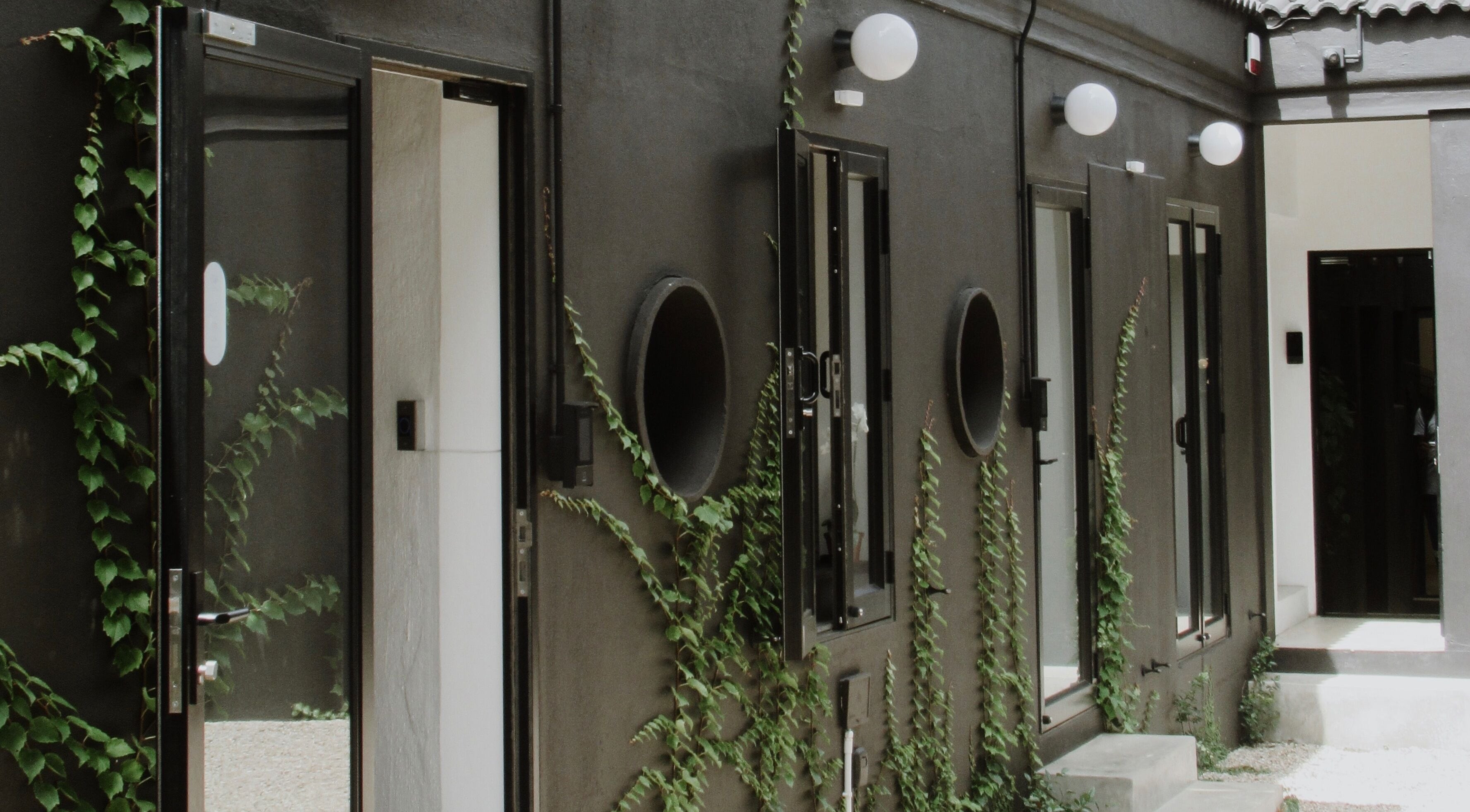 Elegant courtyard at House of Kieulder, Pretoria, Gauteng, ZA with sleek black walls and green vines.