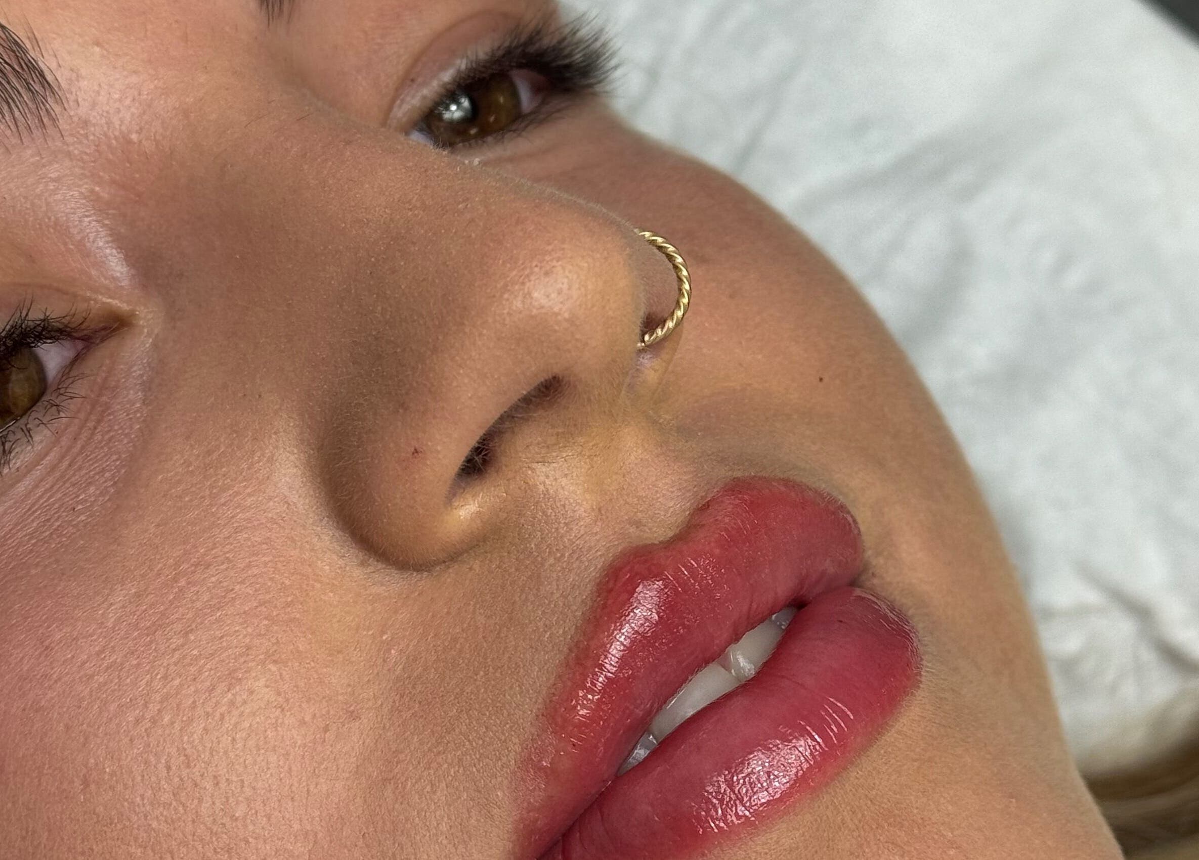 Close-up of a woman with a nose ring and glossy lips at Aesthetics By Paige, Newry, Northern Ireland, GB.