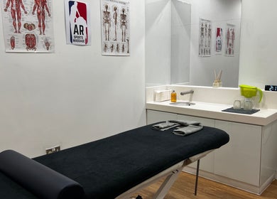 AR Sports Massage treatment room with a massage bed and anatomical charts, London, England, GB.