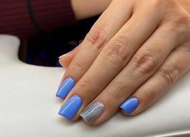 Manicured hand with blue and silver nails at Nail Strike, Lane Cove, New South Wales, AU.