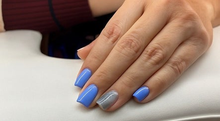 Manicured hand with blue and silver nails at Nail Strike, Lane Cove, New South Wales, AU.