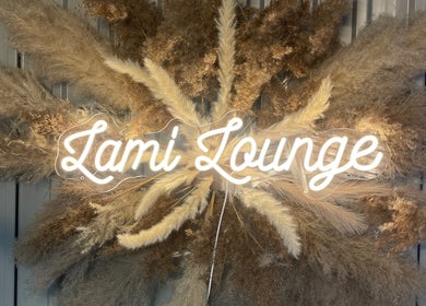 Illuminated sign 'Lami Lounge UK' with pampas backdrop in Spalding, England, GB.