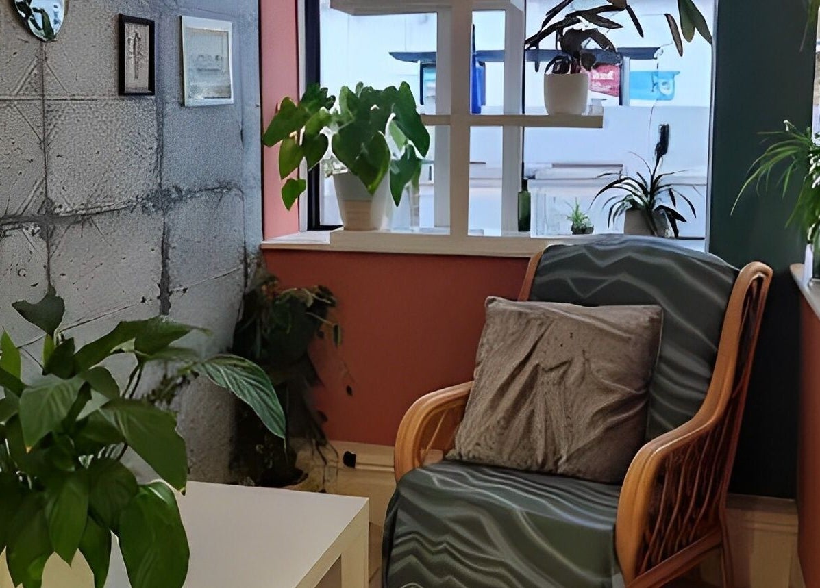 Relaxing nook at Tamed and Wild Fishponds, Bristol, England with plants, cozy chair, and stylish decor.