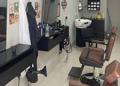 Interior da Barbearia Dom André em São Paulo, poltronas elegantes e estação de trabalho moderna.