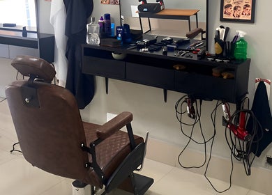 Interior da Barbearia Dom André em São Paulo, com cadeira de barbeiro e produtos de beleza organizados.