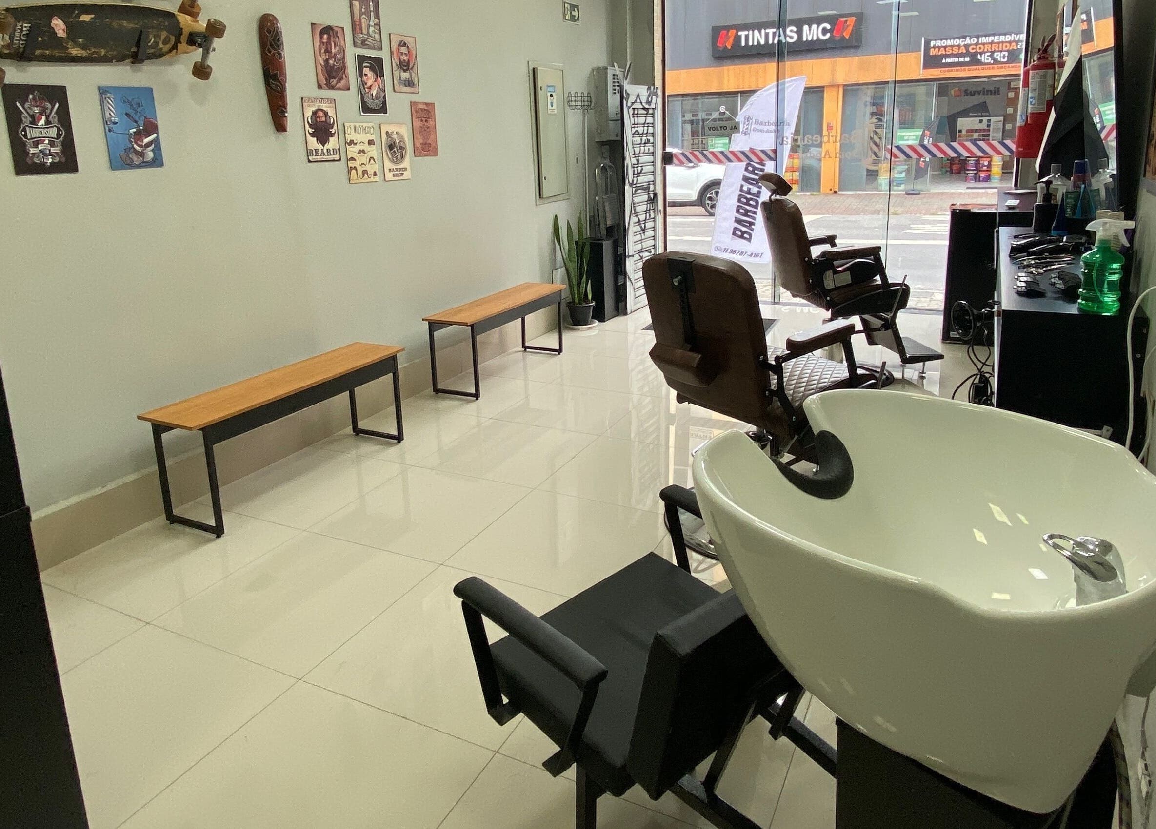 Interior moderno da Barbearia Dom André em São Paulo, SP, com cadeira e lavatório elegantes.