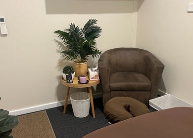 Cozy therapy corner at R.G Motion Therapy, Claremont Meadows, NSW, with chair and plants for relaxation.
