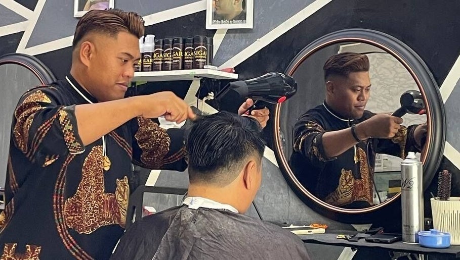 Barber styling a customer's hair at Borneo Barbershop Sabindo, Penampang, Sabah, MY.