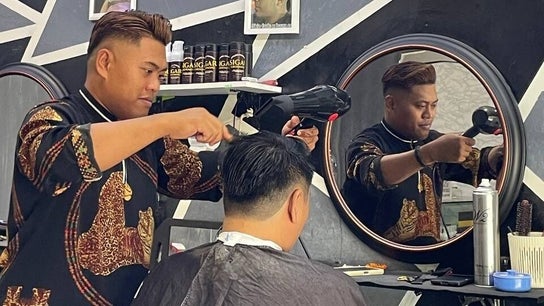 Barber styling a customer's hair at Borneo Barbershop Sabindo, Penampang, Sabah, MY.