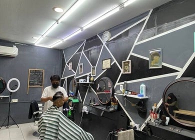 Modern interior of Borneo Barbershop Sabindo in Penampang, Sabah, MY with stylist and client.