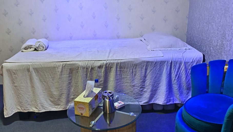 Relaxing massage room at Frozen Thai Spa - Spa in Dhaka, Dhaka Division, BD with blue chair and table.