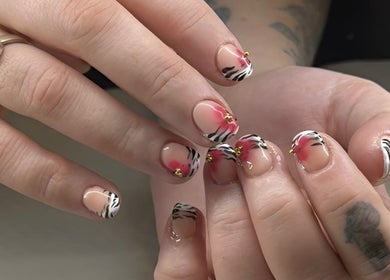 Stylish zebra-patterned nails with floral accents at Aura Beauty Space, Madora Bay, Western Australia, AU.