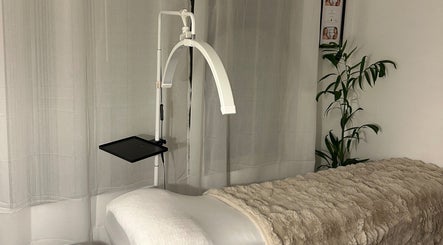 Cozy treatment room at Aura Beauty Space, Madora Bay, Western Australia, AU featuring a plush massage table and plant.