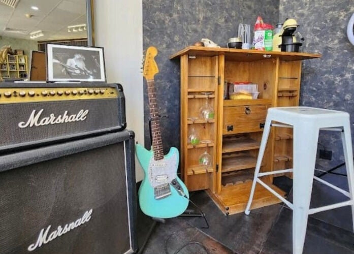 Estúdio musical decorado com guitarra e amplificador em 100 Cortes Expo, Lisboa, Lisboa, PT.