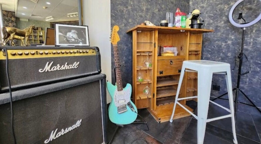 Estúdio musical decorado com guitarra e amplificador em 100 Cortes Expo, Lisboa, Lisboa, PT.