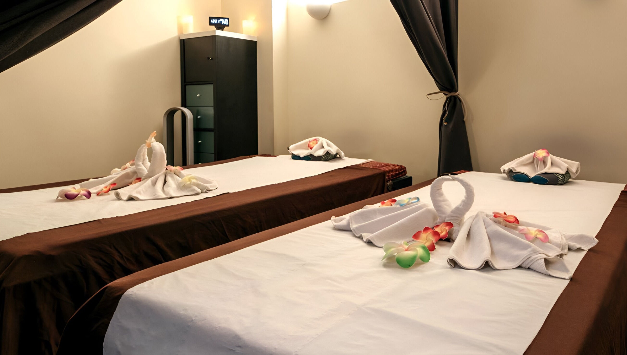 Salle de soin élégante chez Ô Siam Spa Paris 5, Paris, Île-de-France, FR avec tables de massage décorées.