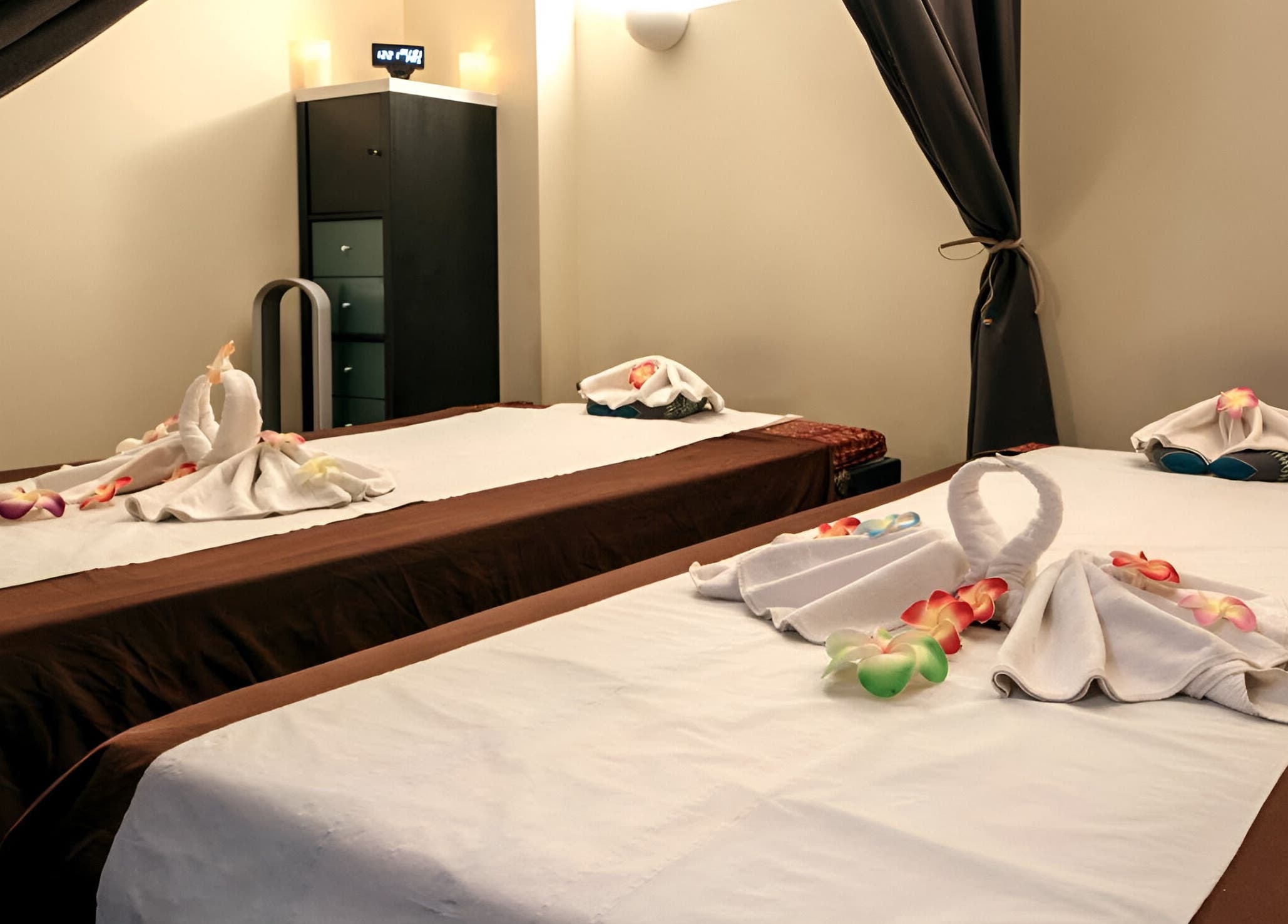 Salle de soin élégante chez Ô Siam Spa Paris 5, Paris, Île-de-France, FR avec tables de massage décorées.