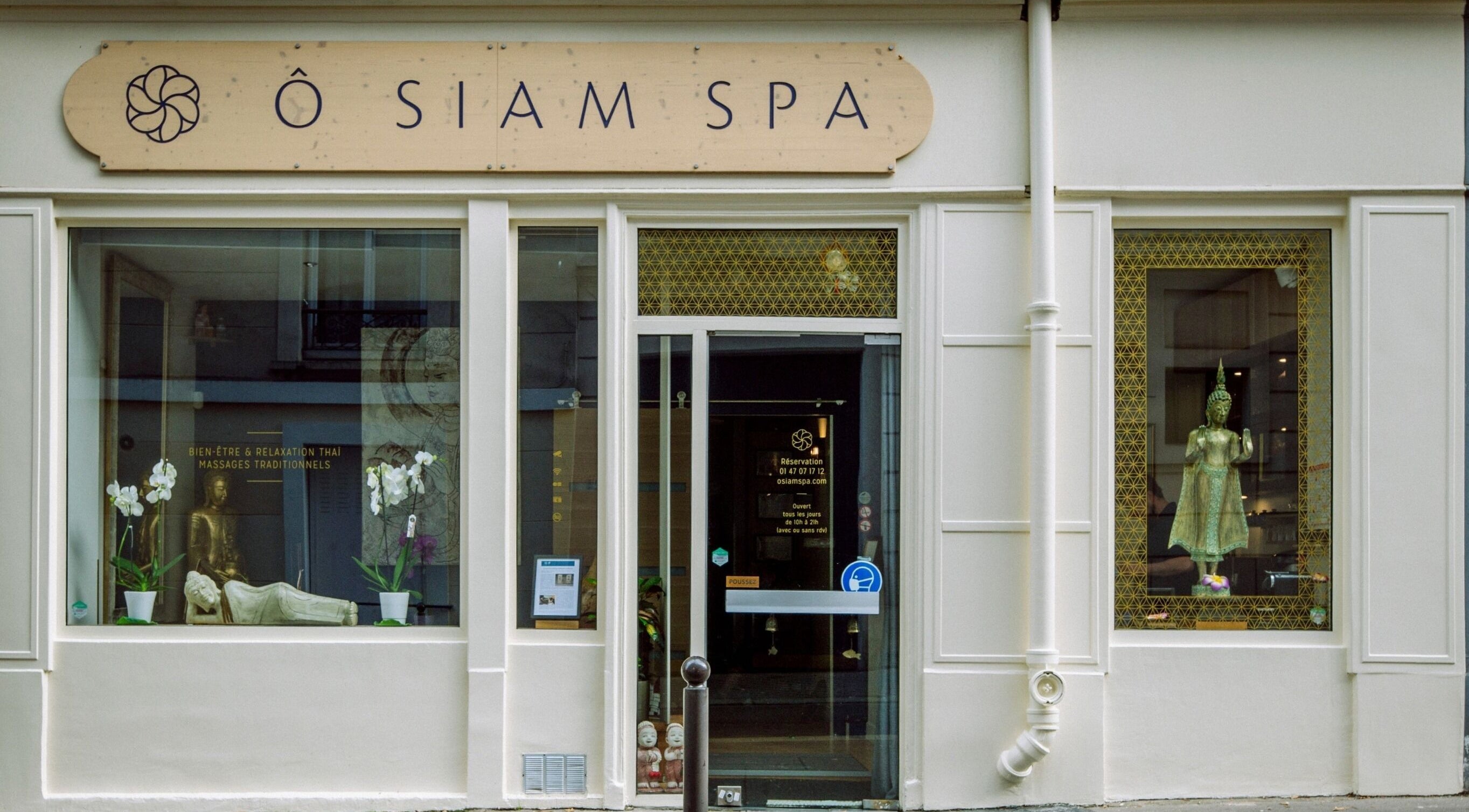 Entrée de Ô Siam Spa Paris 5 à Paris, Île-de-France, FR, avec statue et orchidées en vitrine.