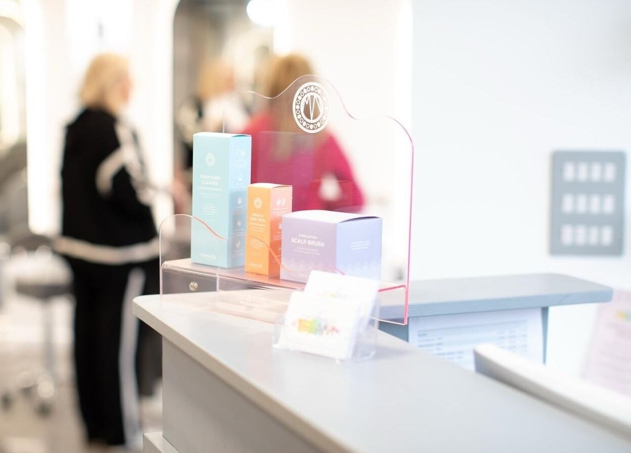 Reception at The House of Glam, Newton-le-Willows, England, displaying beauty products and modern decor.