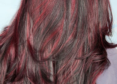 Vibrant red hair highlights styled at B Fierce Salon Barbados, Deanes, Saint James, BB for a stunning look.