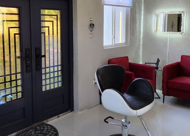 Modern waiting area at B Fierce Salon Barbados, Deanes, Saint James, BB with red chairs and mirrored decor.