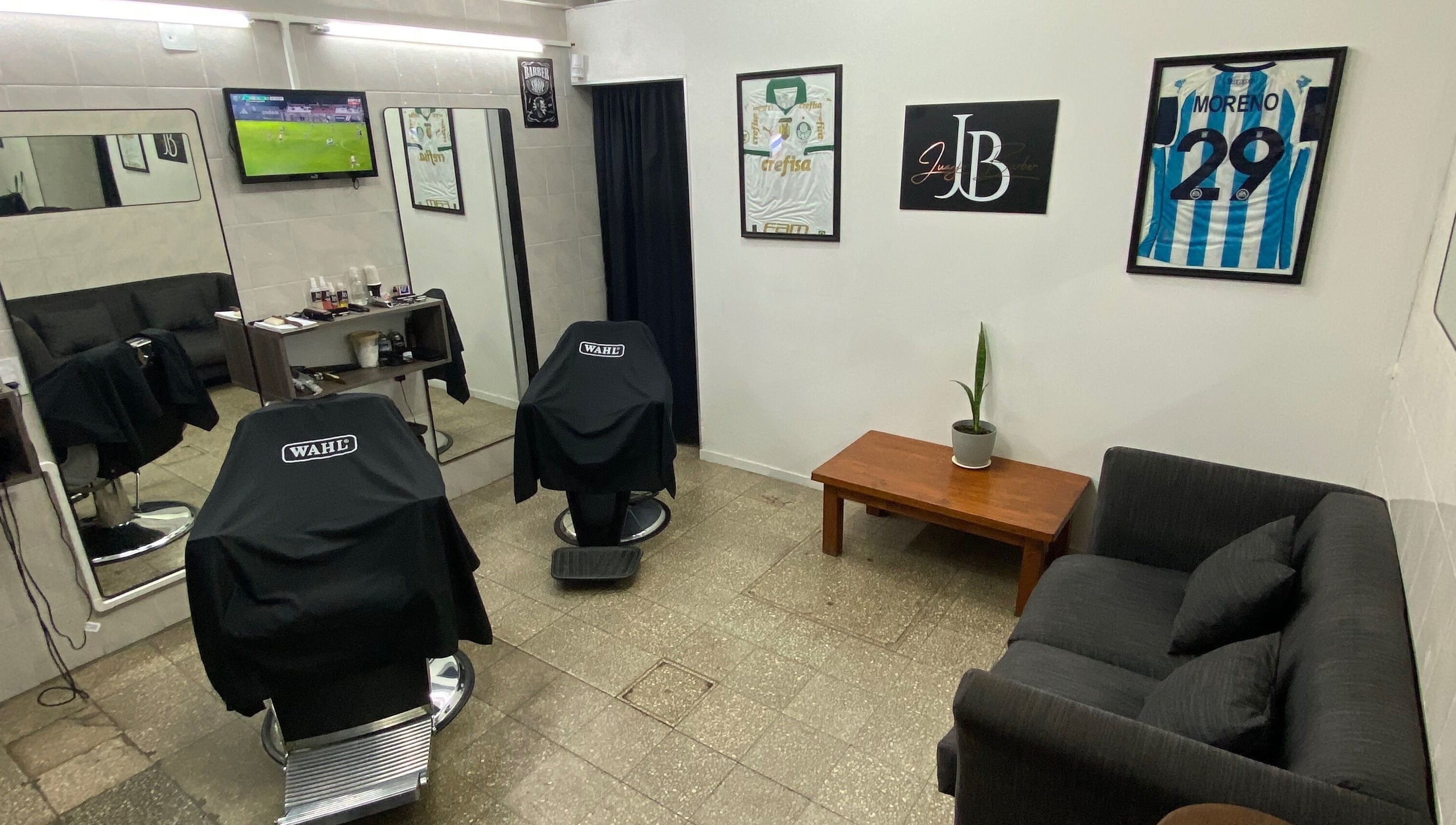 Sala de espera moderna en Juanjo Barber, Rosario, Santa Fe, AR, con sillas y decoraciones elegantes.