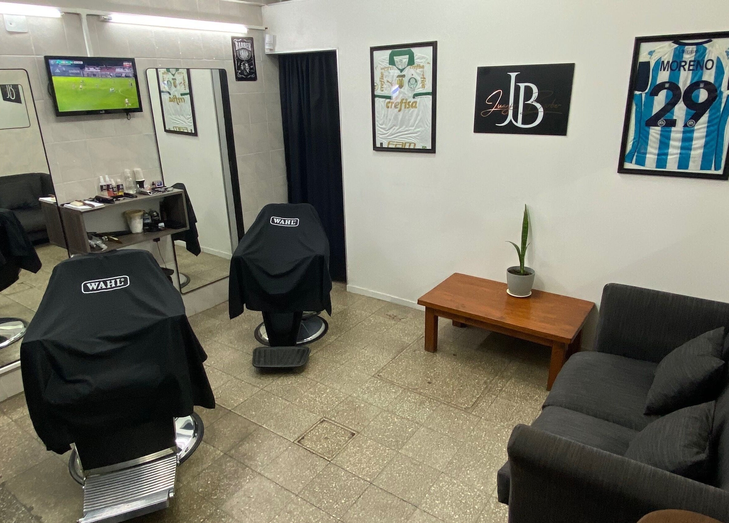 Sala de espera moderna en Juanjo Barber, Rosario, Santa Fe, AR, con sillas y decoraciones elegantes.