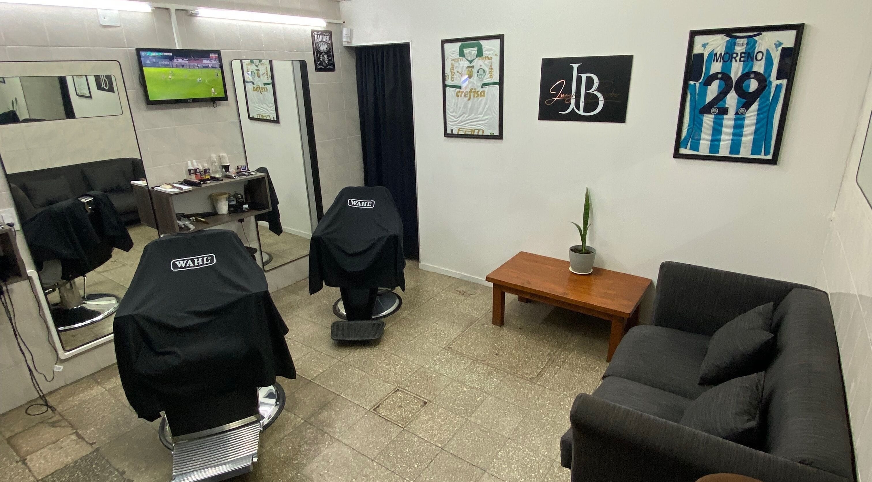 Sala de espera moderna en Juanjo Barber, Rosario, Santa Fe, AR, con sillas y decoraciones elegantes.