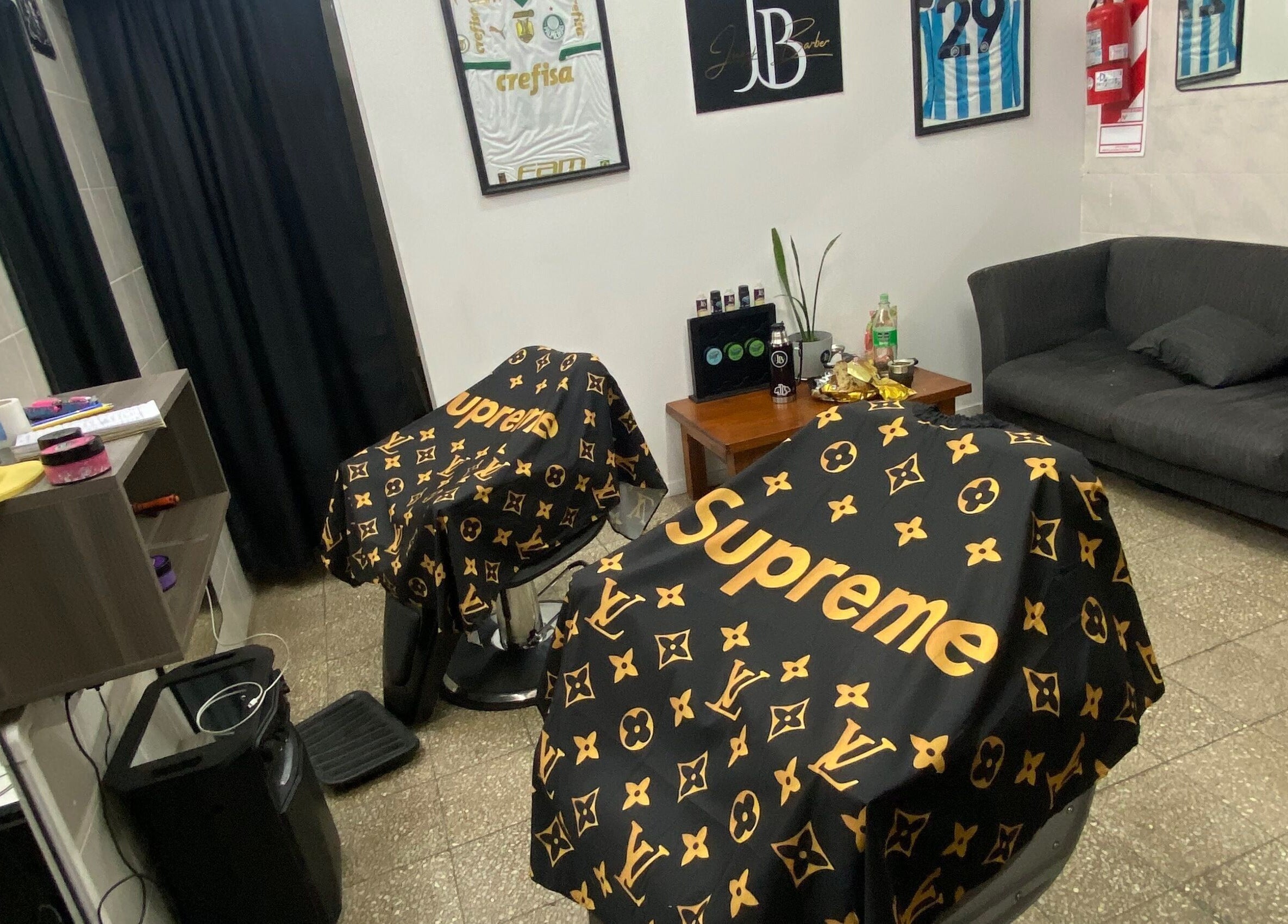 Interior de Juanjo Barber en Rosario, Santa Fe, AR, con sillas cubiertas por capas de diseño.