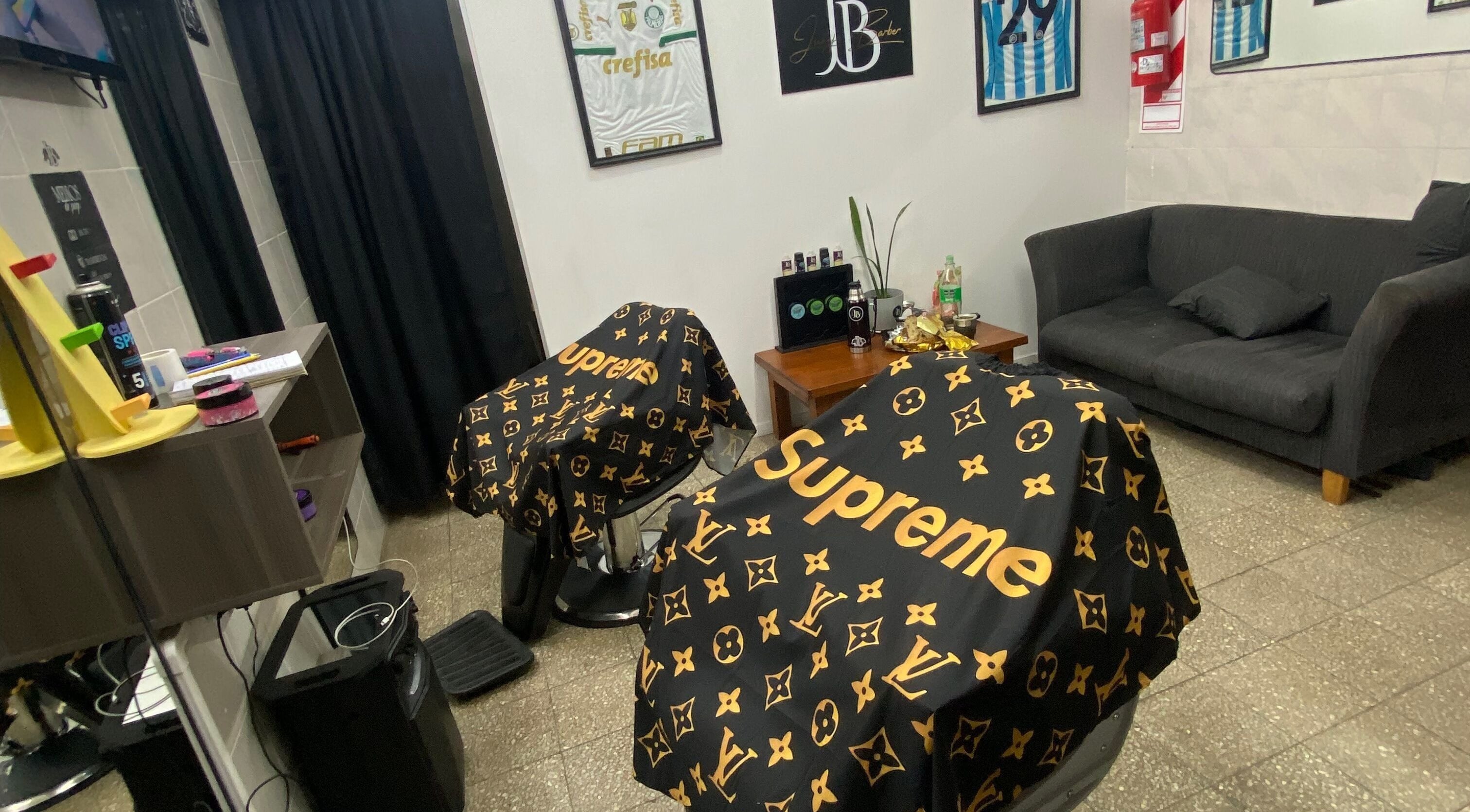 Interior de Juanjo Barber en Rosario, Santa Fe, AR, con sillas cubiertas por capas de diseño.