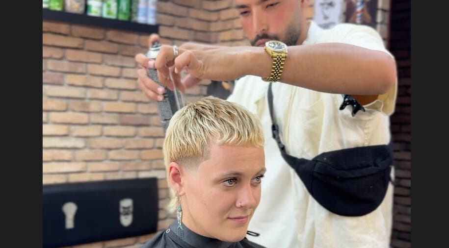 Hairstylist at Omar Alaseer in Amman perfecting a trendy short haircut on a client.