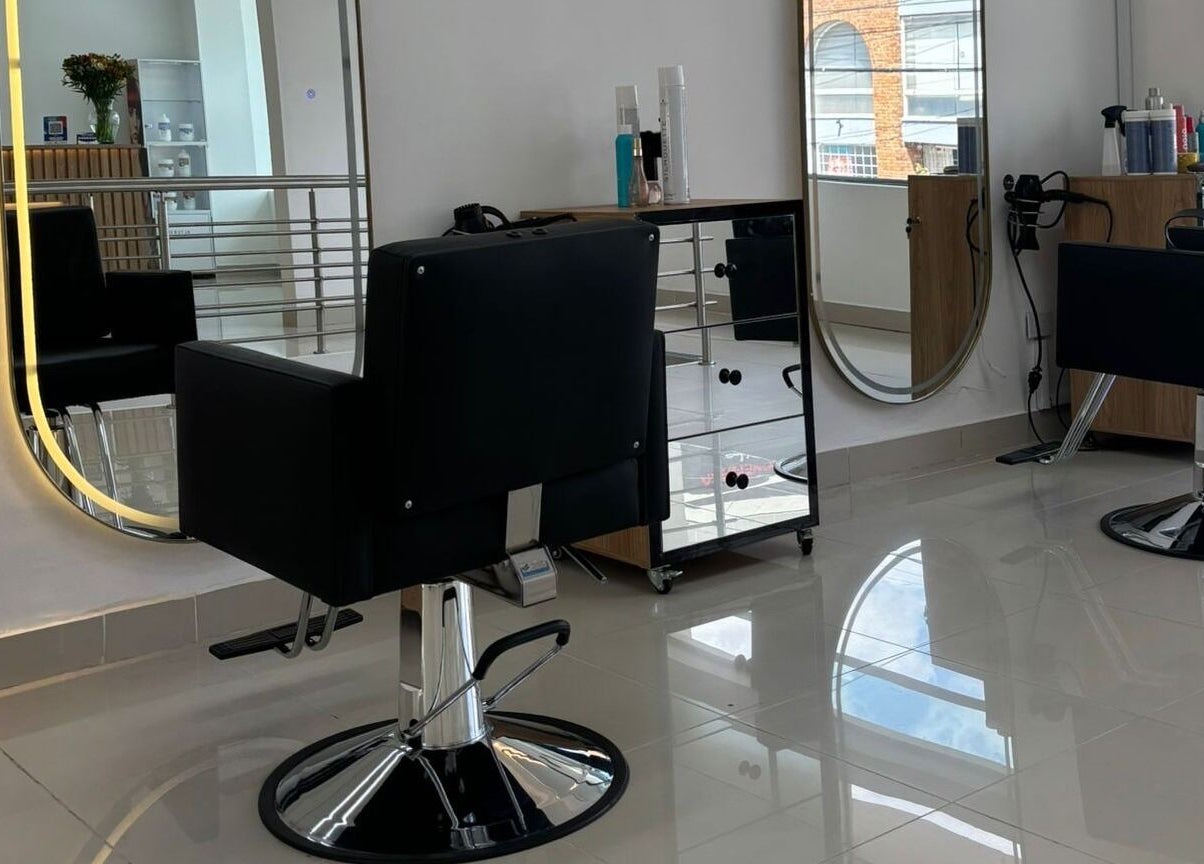 Interior moderno de LUXURY STUDIO MB en Bogotá, Bogotá, CO con sillas de peluquería y espejos elegantes.