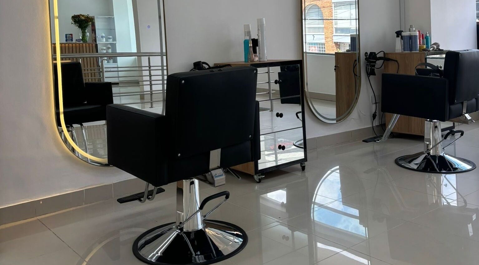 Interior moderno de LUXURY STUDIO MB en Bogotá, Bogotá, CO con sillas de peluquería y espejos elegantes.